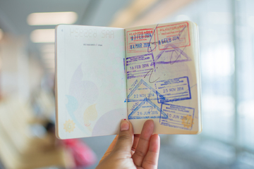 Passaporte aberto mostrando carimbos de entrada e saída de diferentes países
